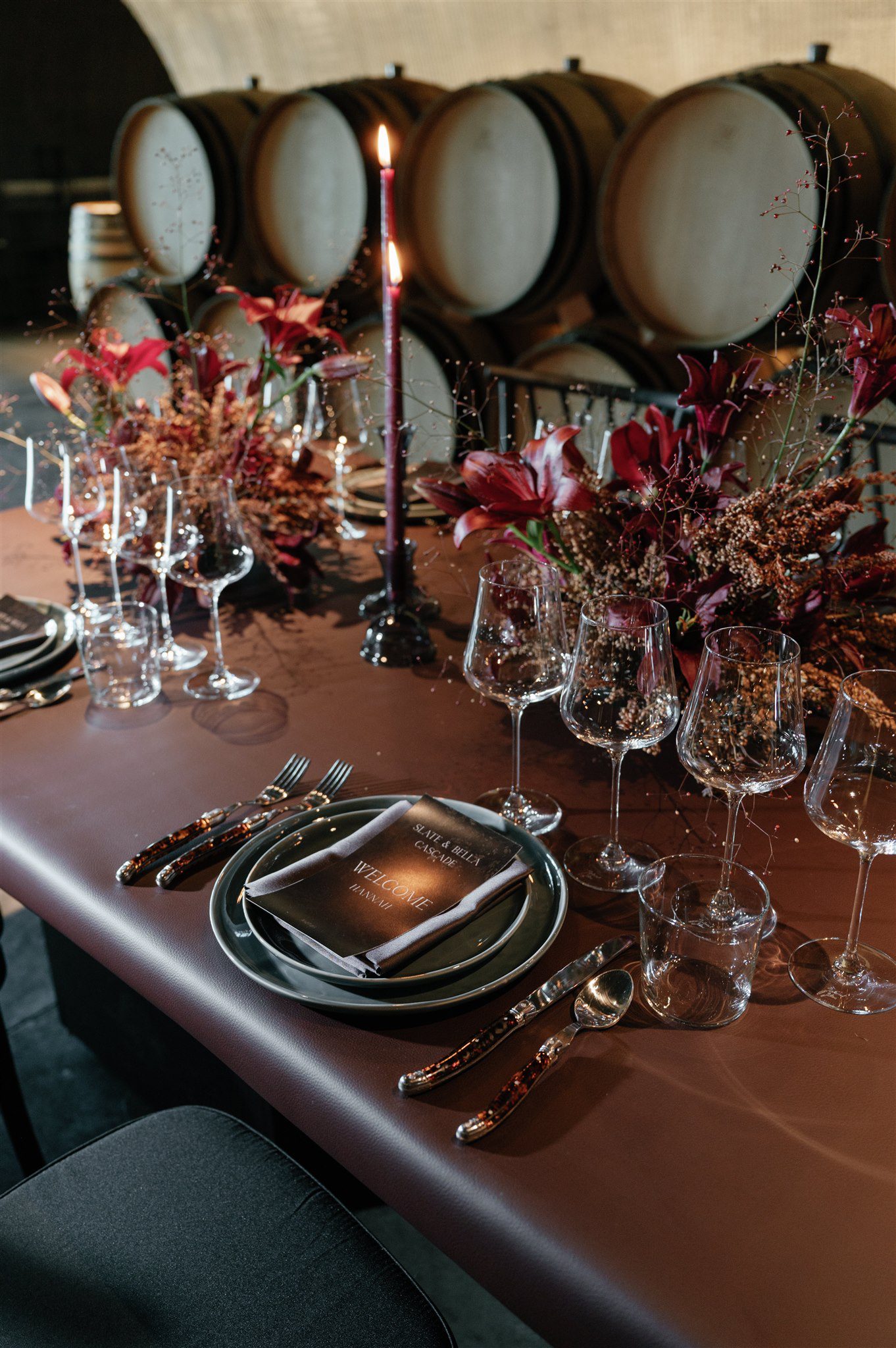 Rehearsal dinner table set inside a barrel-lined wine cave for a wine country wedding.